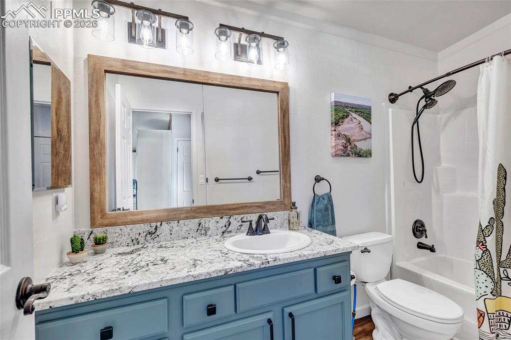 Image 28 of 36: Full bath featuring vanity and shower / bath combo with shower curtain