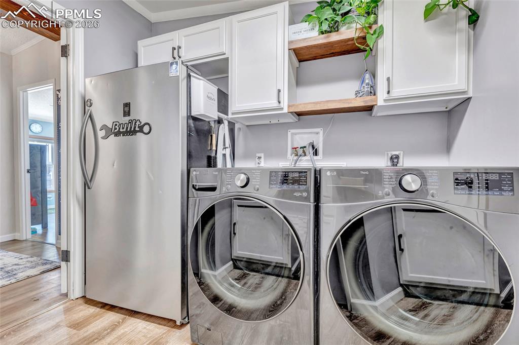 Image 31 of 36: Washroom featuring light wood finished floors, independent washer and dryer