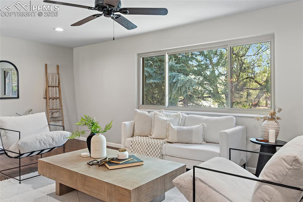 Image 11 of 38: Living room with a ceiling fan, wood finished floors, and recessed lighting