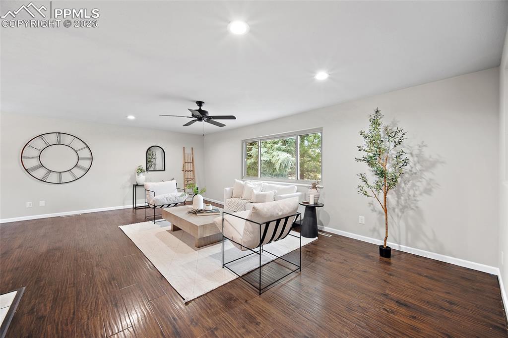Image 12 of 38: Living area featuring dark wood-style flooring, recessed lighting, and a ce