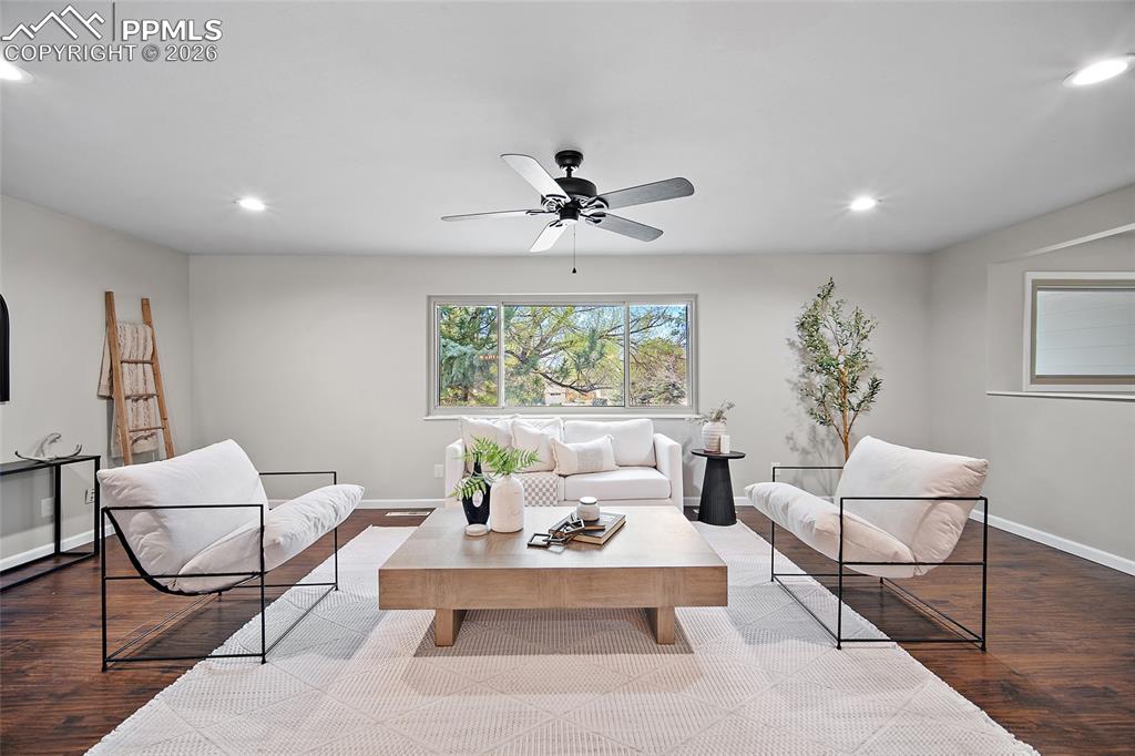 Image 13 of 38: Living room with wood finished floors, a ceiling fan, and recessed lighting