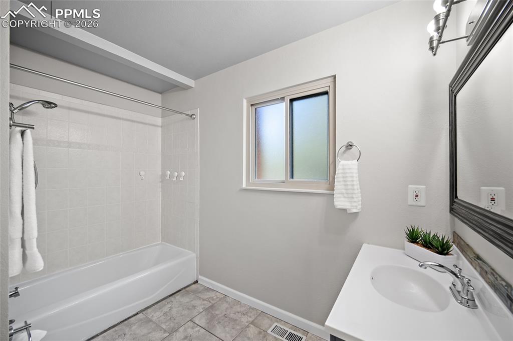 Image 23 of 38: Full bath featuring vanity and shower / washtub combination