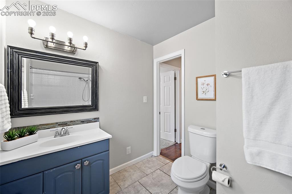 Image 24 of 38: Bathroom with vanity, a shower, and light tile patterned floors