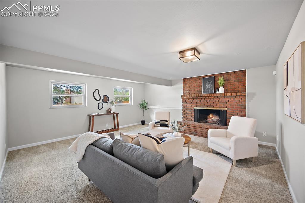 Image 26 of 38: Living room featuring light colored carpet and a brick fireplace