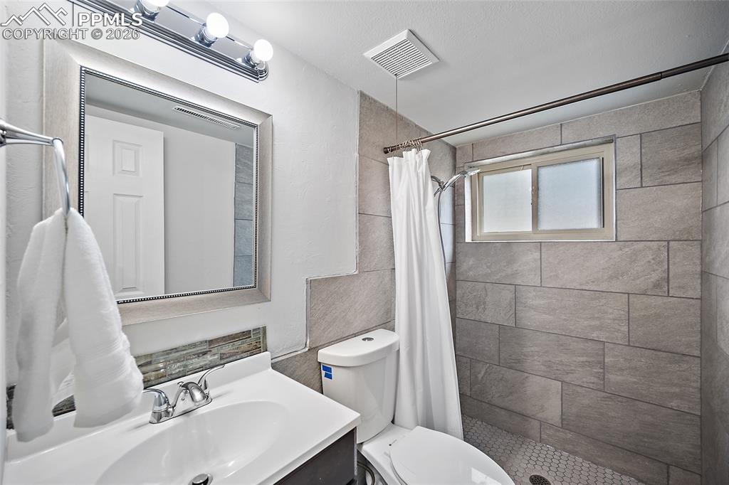 Image 28 of 38: Full bathroom featuring vanity and a shower stall