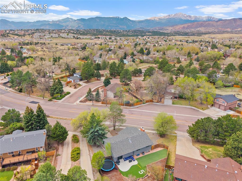Image 37 of 38: Aerial view of residential area featuring a mountain backdrop