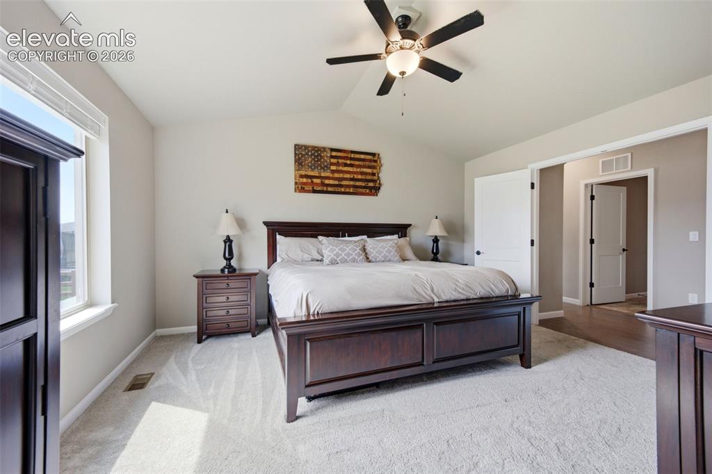 Image 18 of 45: French Doors welcome you to the primary bedroom with soaring ceilings and a