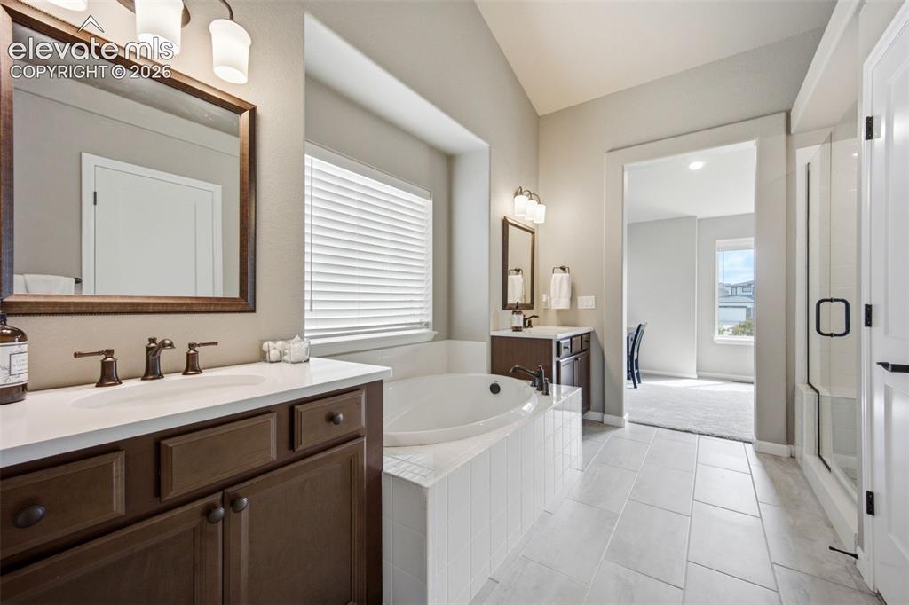 Image 22 of 45: Enjoy the large soaking tub and separate vanities