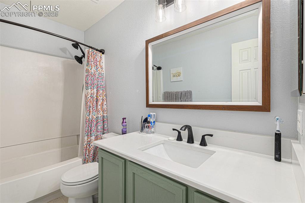 Image 12 of 21: Full bathroom featuring toilet, vanity, and shower / tub combo with curtain