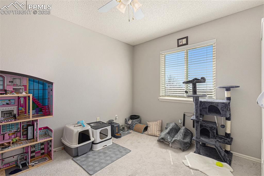 Image 13 of 21: Game room featuring carpet floors, ceiling fan, baseboards, and a textured 