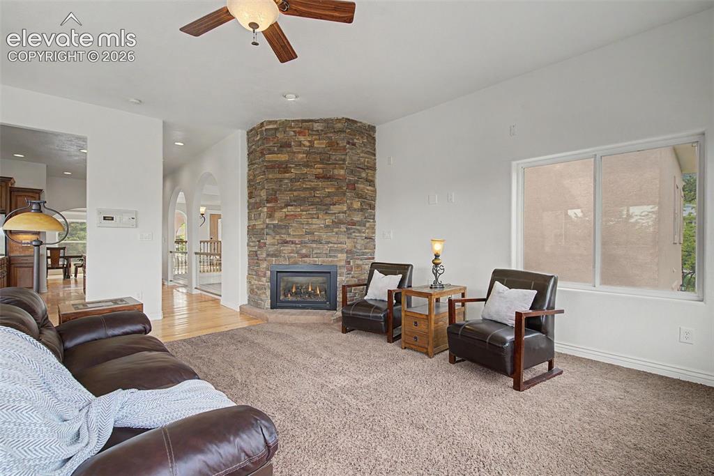 Image 13 of 50: Stone fireplace creates a warm focal point in the formal living room