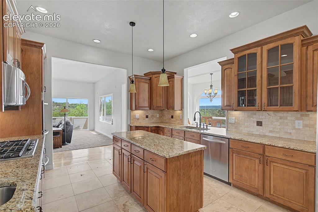 Image 14 of 50: Designer kitchen with granite countertops, center island, and extensive cab