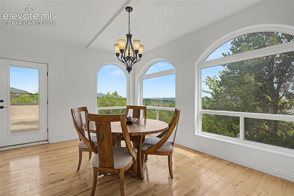 Image 18 of 50: Breakfast nook surrounded by arched windows and foothill views