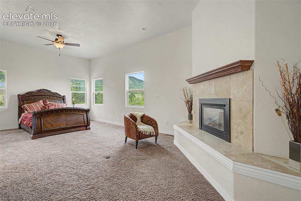 Image 20 of 50: Gas fireplace creates a warm focal point within the spacious primary retrea