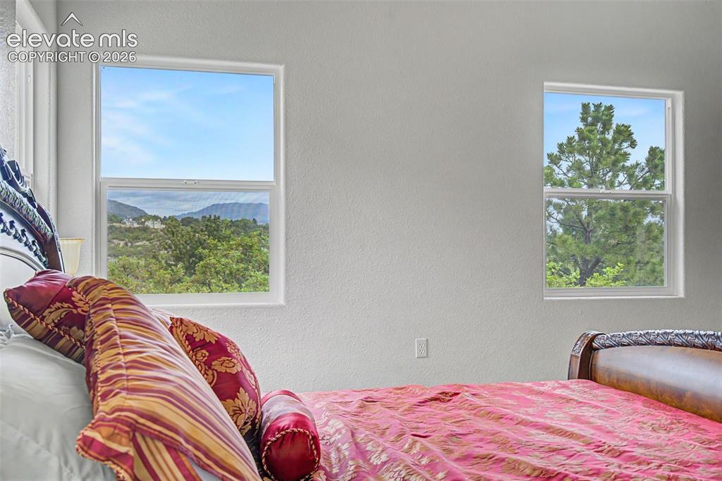 Image 21 of 50: Windows frame views of the surrounding foothills and mature landscape