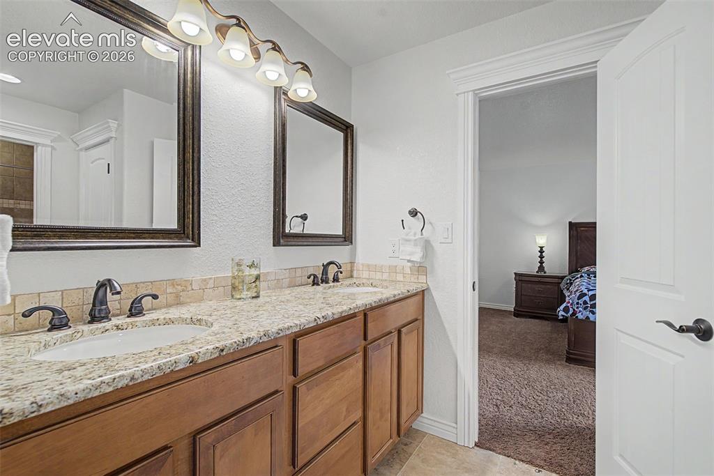 Image 27 of 50: Shared Hollywood bathroom featuring dual sinks and private access from adjo