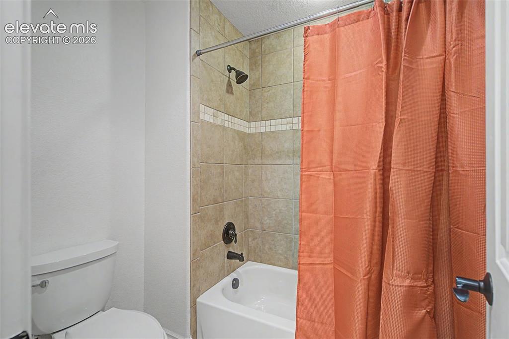 Image 28 of 50: Well-appointed Hollywood bathroom with tile-surround tub/shower, connecting