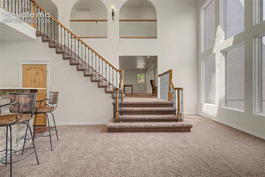 Image 32 of 50: Dramatic lower-level entertaining area featuring soaring ceilings, floor-to