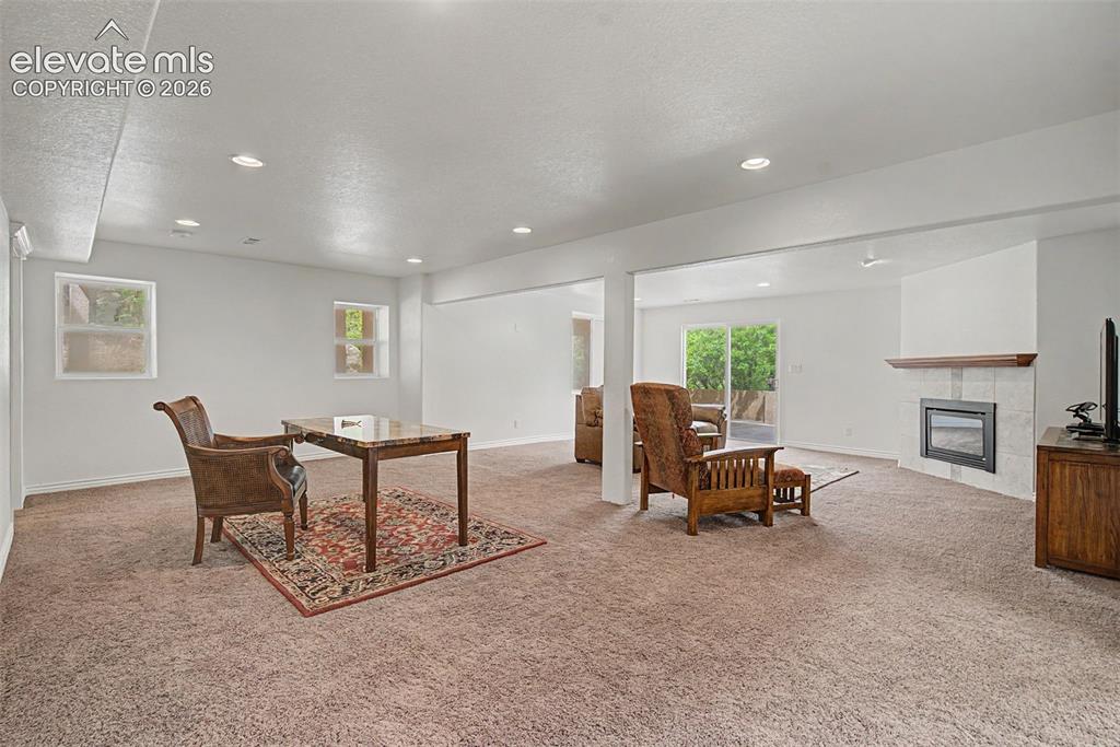 Image 34 of 50: Expansive walk-out family room offering multiple gathering areas and direct