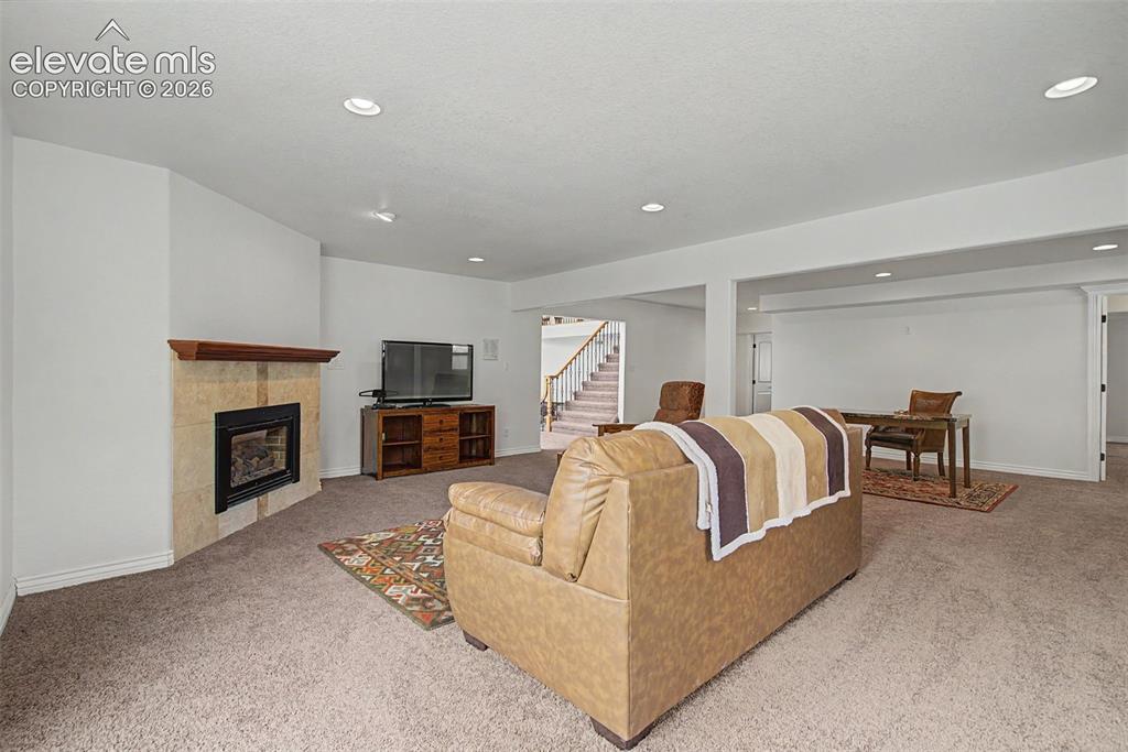 Image 35 of 50: Lower-level family room featuring a gas fireplace and abundant space for en