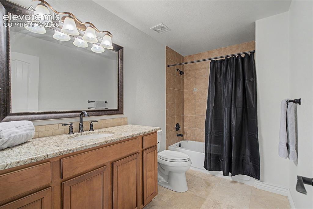 Image 38 of 50: Full bathroom with granite vanity, tile flooring, and tub/shower combinatio