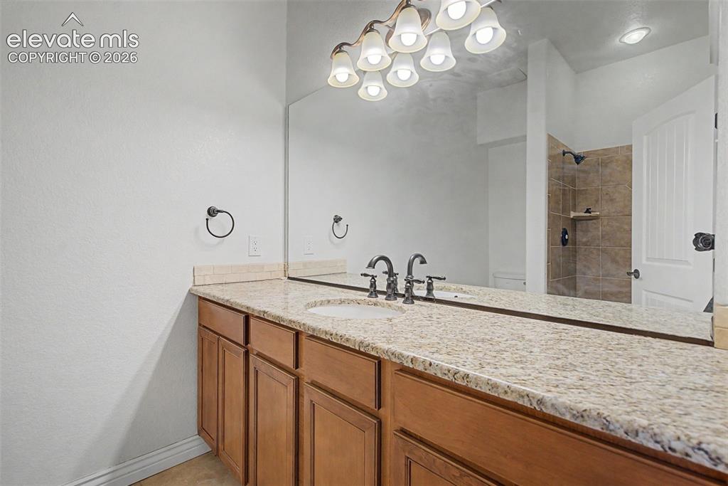 Image 41 of 50: Lower-level 3/4 bathroom with granite vanity and tiled walk-in shower, conv