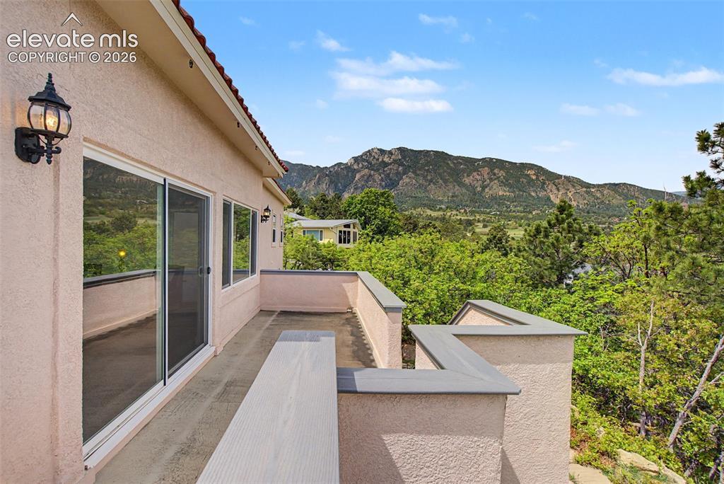 Image 44 of 50: Elevated deck overlooking mature trees, golf course surroundings, and the f