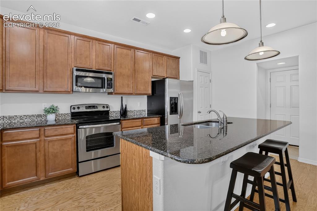 Image 9 of 23: SS appliances & island w/ barstool seating