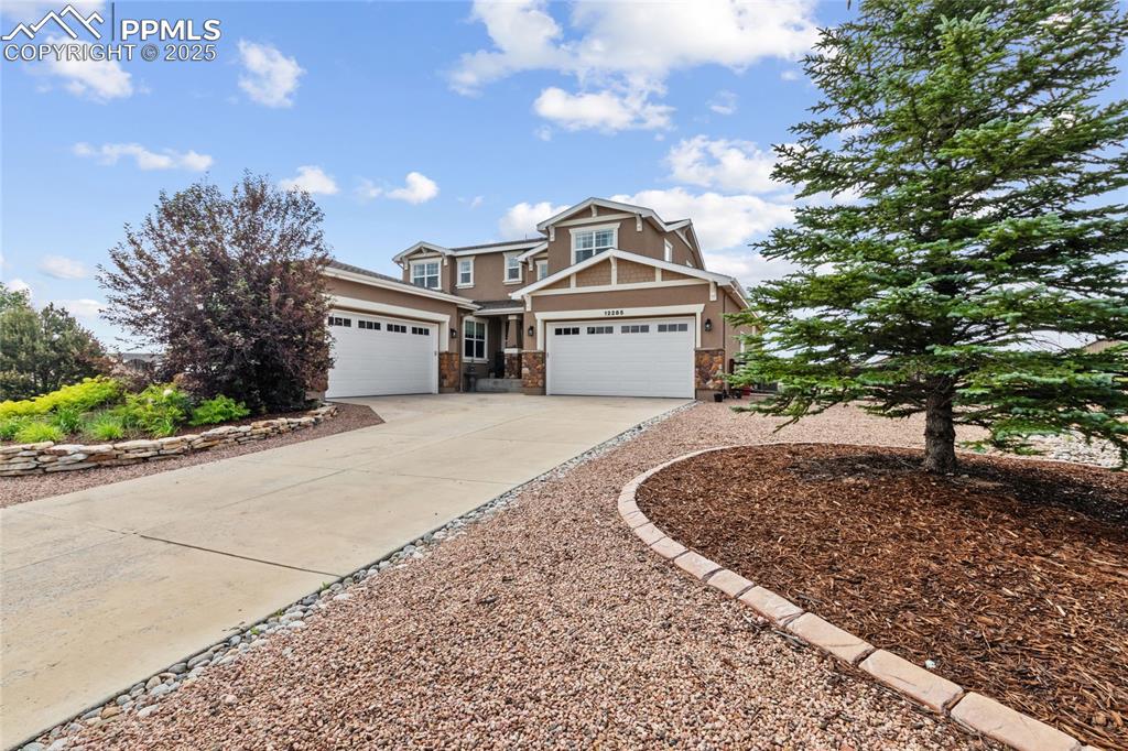 Caption: Craftsman-style house with driveway, a garage, stone siding, and stucco siding