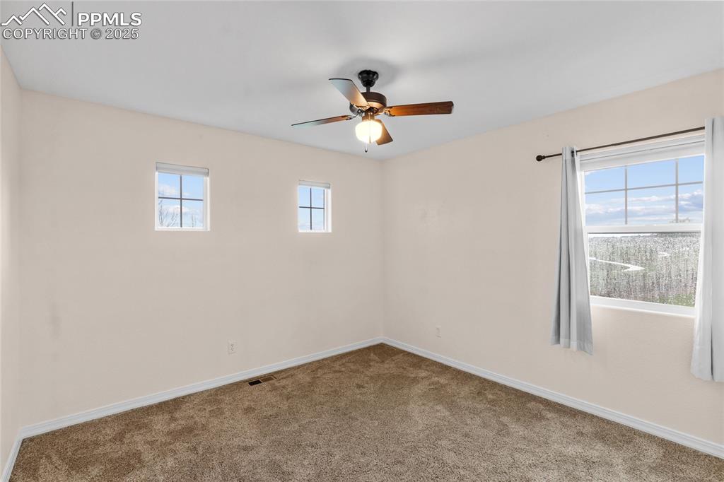 Image 14 of 36: Carpeted empty room featuring a ceiling fan and baseboards