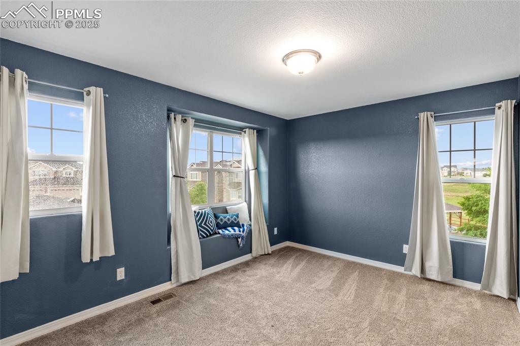Image 17 of 36: Spare room with carpet and a textured ceiling