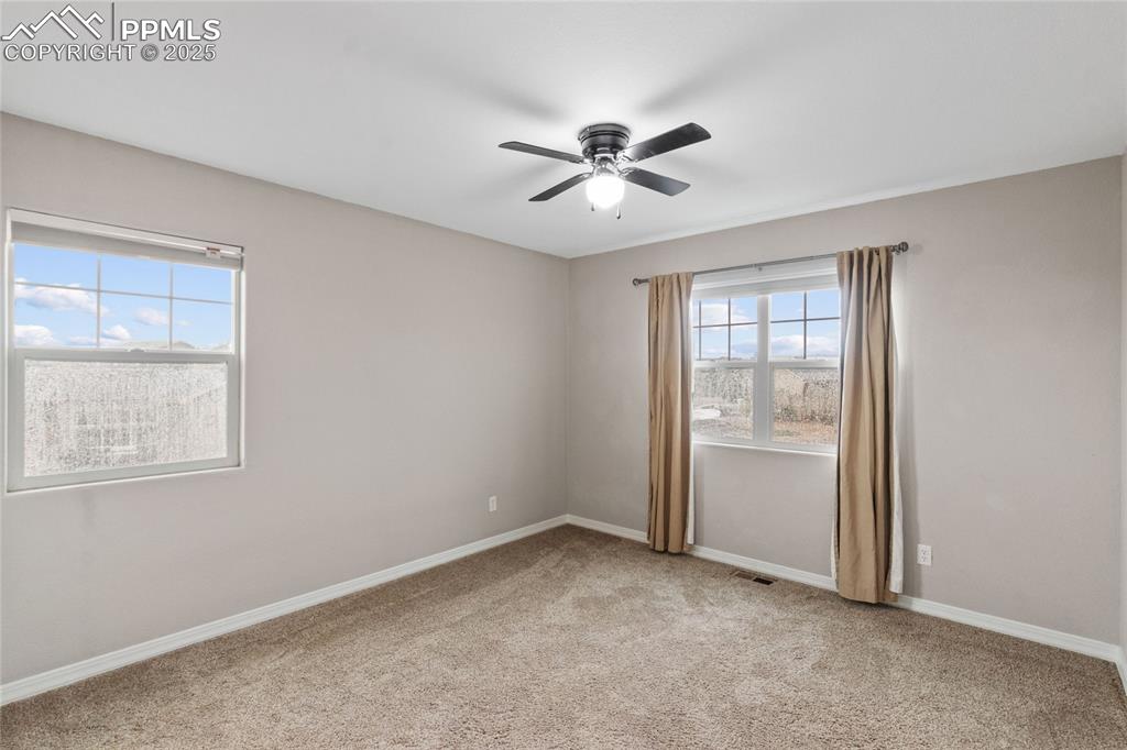 Image 20 of 36: Unfurnished room featuring a ceiling fan and light carpet