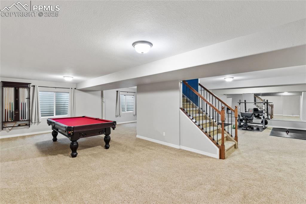 Image 25 of 36: Recreation room with carpet, pool table, and a textured ceiling