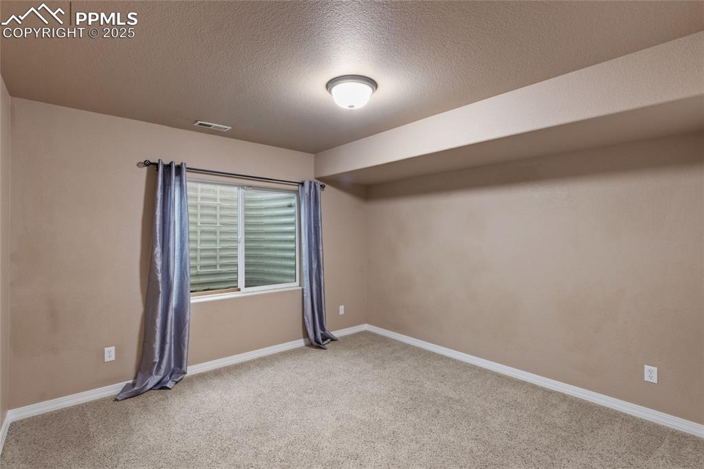 Image 28 of 36: Spare room featuring carpet floors and a textured ceiling