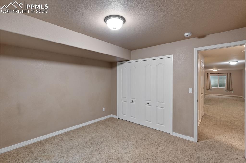 Image 29 of 36: Unfurnished bedroom with carpet, a closet, and a textured ceiling