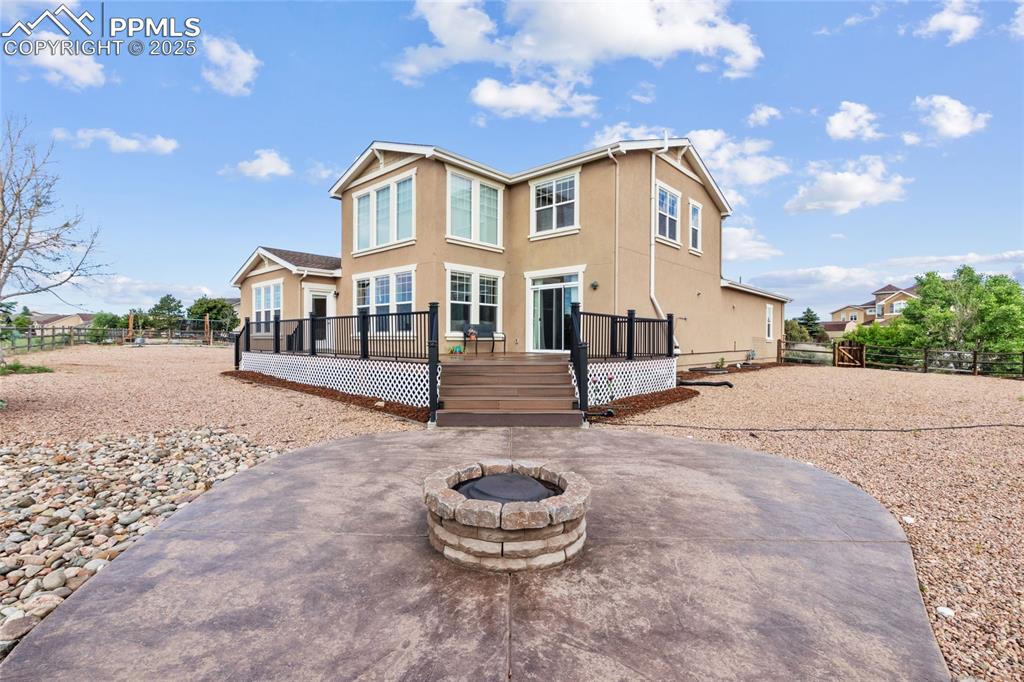 Image 34 of 36: Back of house featuring an outdoor fire pit, a patio, a deck, and stucco si