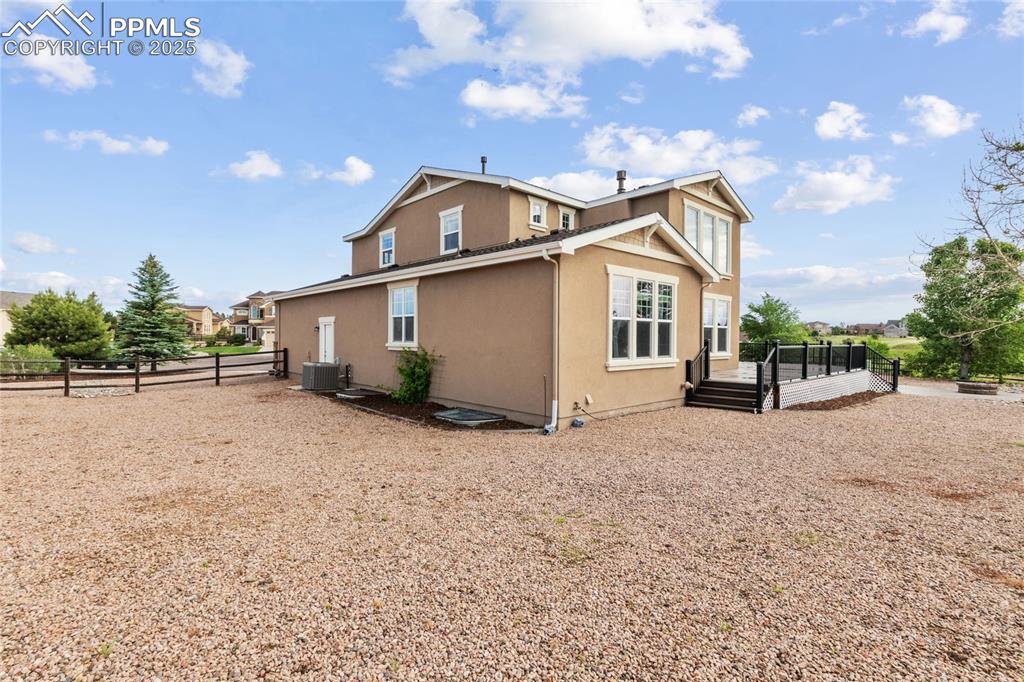 Image 36 of 36: View of side of property with stucco siding and a wooden deck