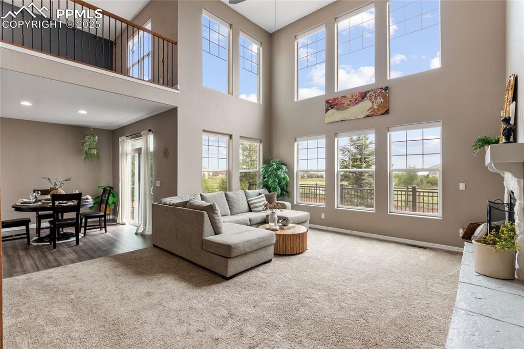 Image 4 of 36: Living room with a high ceiling and wood finished floors