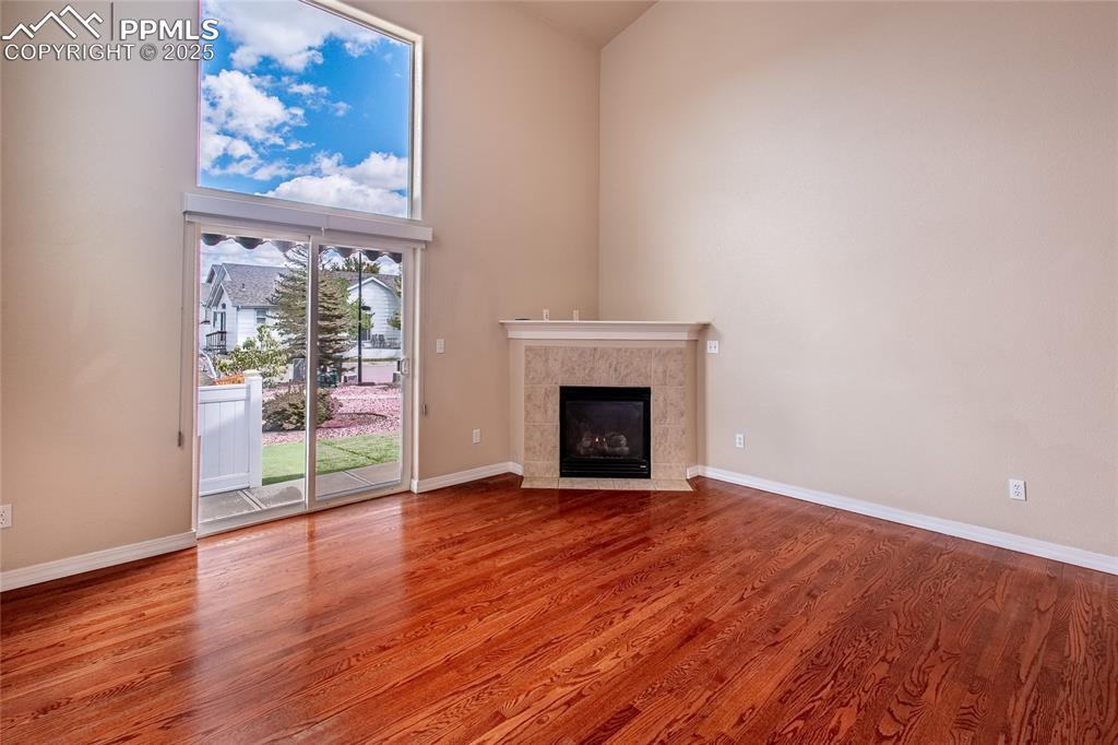 Image 11 of 47: Unfurnished living room with light wood-style flooring, a tile fireplace, a