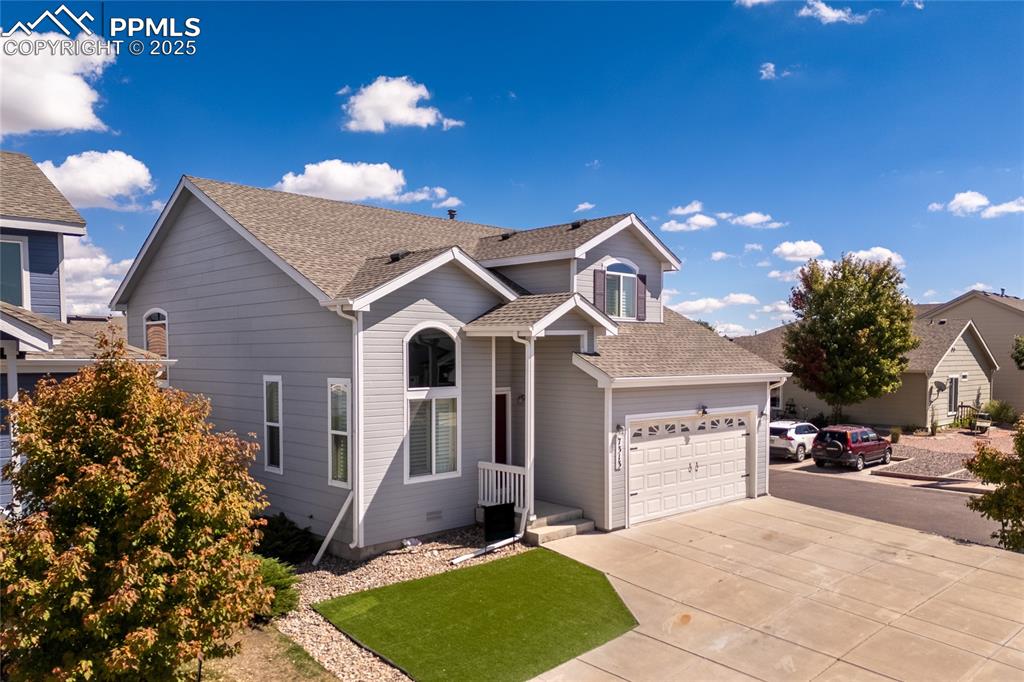 Image 2 of 47: Traditional-style house with roof with shingles, driveway, and a garage