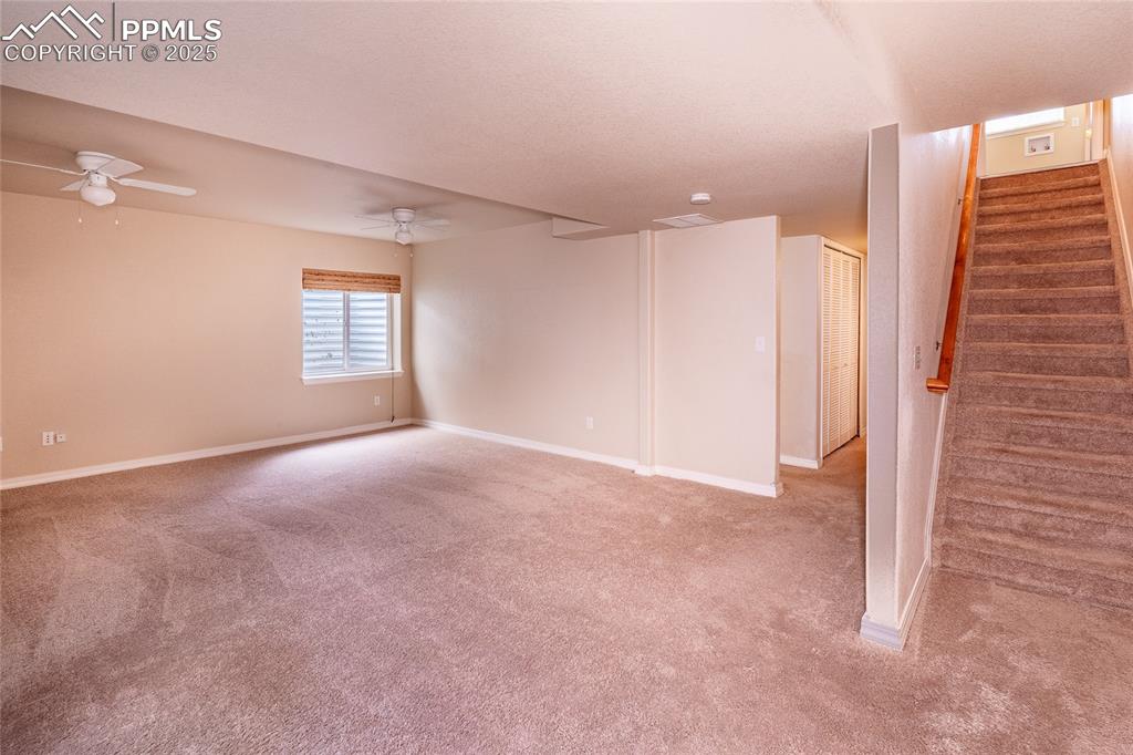Image 20 of 47: Basement featuring stairs and light carpet