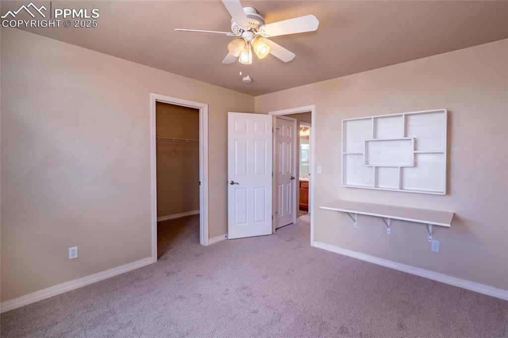 Image 22 of 47: Unfurnished bedroom featuring light carpet, a walk in closet, and ceiling f