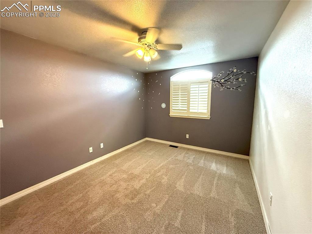 Image 30 of 47: Carpeted empty room with a textured ceiling, ceiling fan, and a textured wa