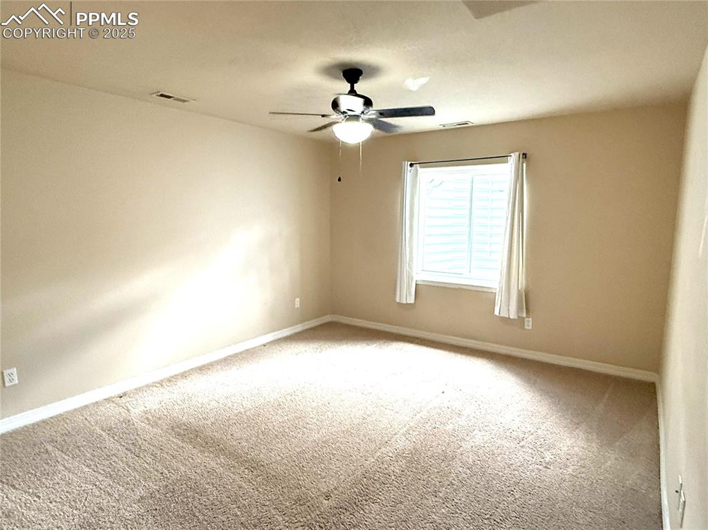 Image 33 of 47: Carpeted spare room featuring baseboards and ceiling fan