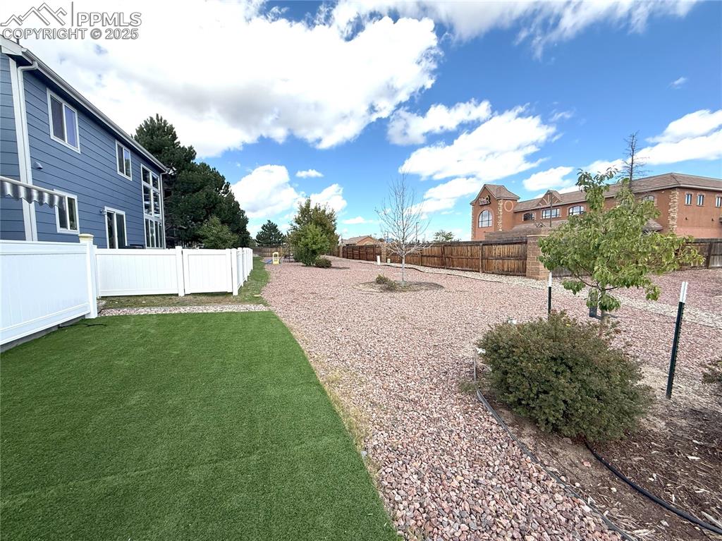 Image 35 of 47: Fenced backyard with a residential view