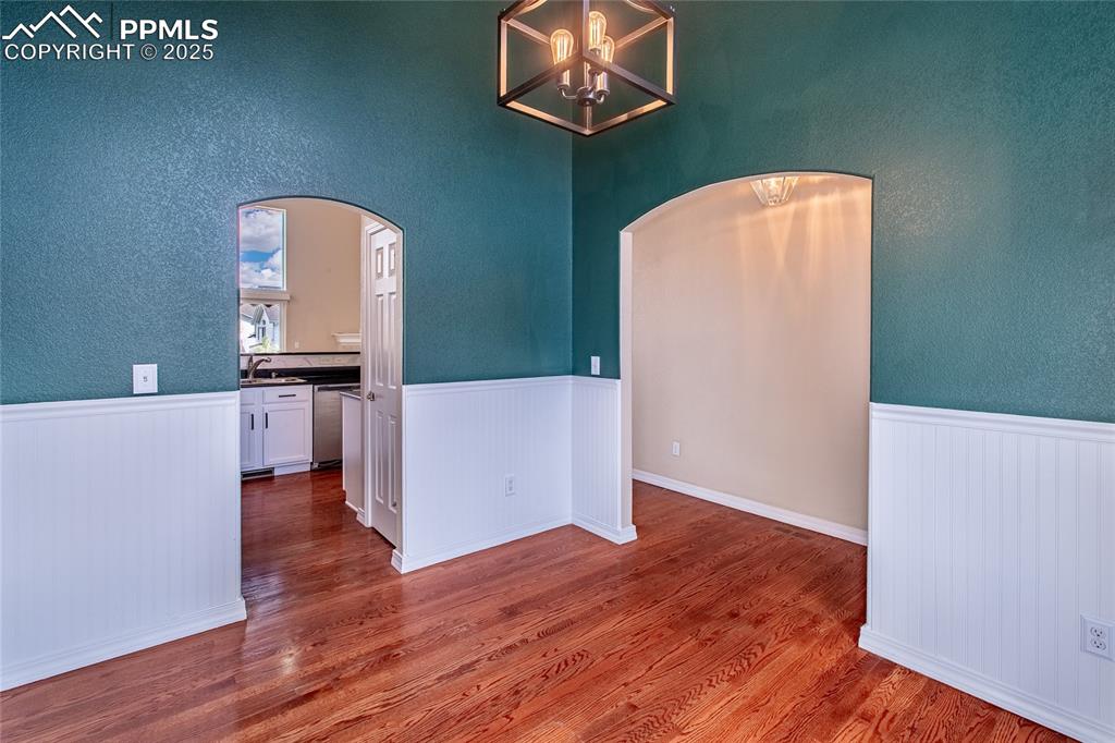 Image 4 of 47: Unfurnished dining area featuring dark wood finished floors, a textured wal