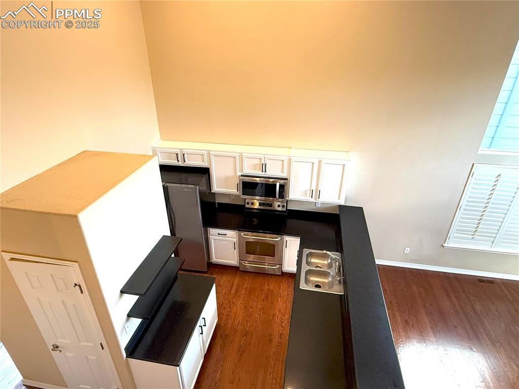 Image 9 of 47: Kitchen featuring white cabinetry, appliances with stainless steel finishes