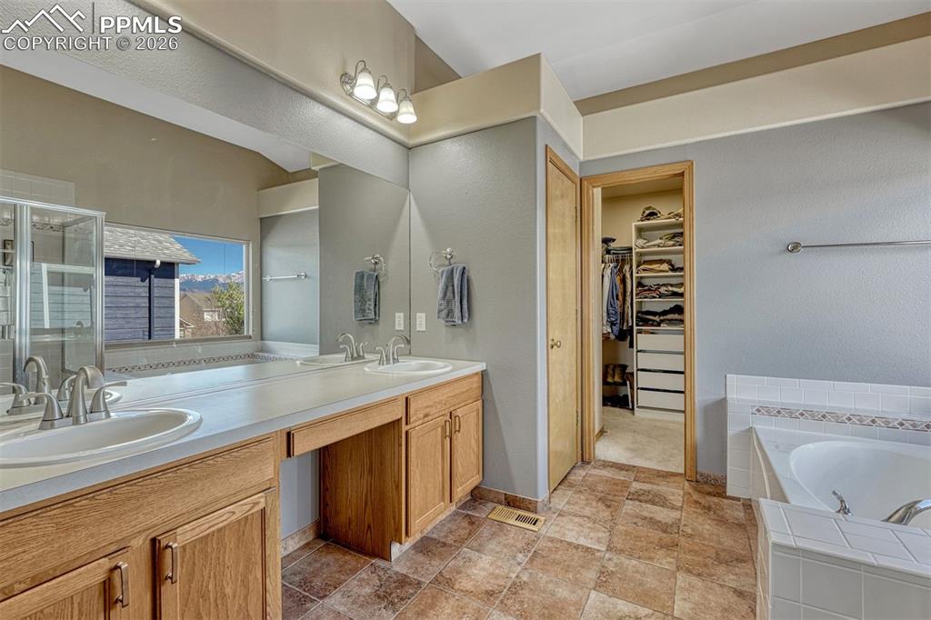 Image 23 of 40: Primary 5 piece bathroom vanity featuring dual sinks, wood-finish cabinetry