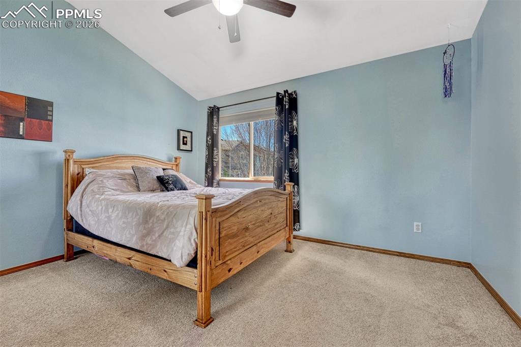 Image 26 of 40: Vaulted ceiling in a room featuring light blue walls, a window with dark pa