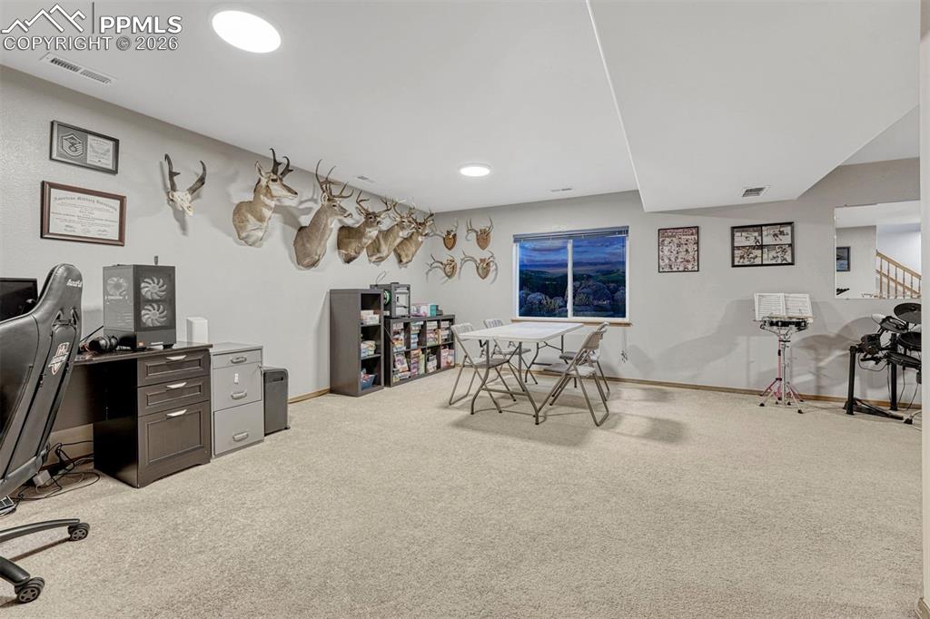 Image 31 of 40: Spacious carpeted room featuring a window, recessed lighting, and access to